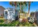 Backyard storage shed with a ramp, adjacent to a wood fence and palm trees at 3403 Kumquat Dr, Edgewater, FL 32141