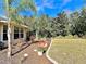 Well-maintained backyard with a tidy lawn, rock border, decorative bridge and manicured landscaping at 3435 Black Willow Trl, Deland, FL 32724