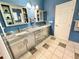 Bathroom showcasing a double sink vanity with granite countertop, cabinets, and tiled flooring at 3435 Black Willow Trl, Deland, FL 32724