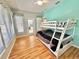 Bright bedroom features a bunk bed, hardwood floors, and a view of the outdoors at 3435 Black Willow Trl, Deland, FL 32724