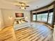 Bright bedroom featuring a ceiling fan, hardwood floors, a white frame bed, and natural light at 3435 Black Willow Trl, Deland, FL 32724