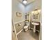 Traditional half bathroom features a pedestal sink, decorative mirror, and patterned wallpaper at 3435 Black Willow Trl, Deland, FL 32724