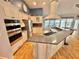 Open kitchen featuring stainless appliances, island with seating, and white cabinets at 3435 Black Willow Trl, Deland, FL 32724