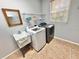 Functional laundry room features a washer, dryer, utility sink, and ample storage space above at 3435 Black Willow Trl, Deland, FL 32724