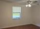 Bedroom with hardwood flooring, a ceiling fan, and a window offering natural light at 36 Fairway Ct # 36, Deland, FL 32724