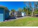 Backyard view with storage trailer and shed, grassy lawn, and fencing at 3683 Jackson St, Port Orange, FL 32129