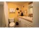 Cozy yellow bathroom featuring a toilet, shower, vanity, mirror and decorative fish at 3700 S Atlantic Ave # 315, New Smyrna Beach, FL 32169