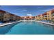 Large community pool surrounded by lounge chairs and multi-story building at 3801 S Atlantic Ave # Ut125, New Smyrna Beach, FL 32169