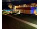 Nighttime view of the pool area and building exterior with illuminated palm trees at 3801 S Atlantic Ave # Ut125, New Smyrna Beach, FL 32169