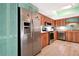 Stylish kitchen with wood cabinets, stainless steel refrigerator, and mosaic backsplash, creating a warm space at 4035 Saxon Dr # A3, New Smyrna Beach, FL 32169