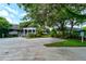 Exterior view of the community building with manicured landscaping, mature trees, and ample parking at 4322 Sea Mist Dr # 4322, New Smyrna Beach, FL 32169