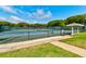 Well-maintained tennis court with surrounding fence and an adjacent covered seating area at 4322 Sea Mist Dr # 4322, New Smyrna Beach, FL 32169
