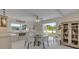 Sunlit dining area featuring sleek white chairs, glass table, and seamless transition to outdoor deck for entertaining at 4624 Van Kleeck Dr, New Smyrna Beach, FL 32169