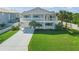 Charming two-story home with double balconies, a well-manicured lawn, and a long concrete driveway at 4624 Van Kleeck Dr, New Smyrna Beach, FL 32169
