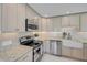 Contemporary kitchen showcasing stainless steel appliances, white cabinets, and granite countertops at 4624 Van Kleeck Dr, New Smyrna Beach, FL 32169
