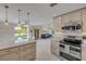 Open kitchen with stainless steel appliances, modern countertops, and a view of the dining and living areas at 4624 Van Kleeck Dr, New Smyrna Beach, FL 32169