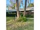 A charming home framed by palm trees and manicured hedges bursting with vibrant pink flowers adds to the curb appeal at 485 Merrimac Dr, Port Orange, FL 32127
