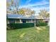 Charming single-story home featuring a lush green lawn, decorative porch columns, and vibrant flowering shrubs at 485 Merrimac Dr, Port Orange, FL 32127