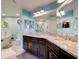 Bathroom featuring double sinks, a marble countertop, light-blue paint, and a walk-in shower at 5 Riverwalk Dr # 506, New Smyrna Beach, FL 32169