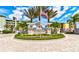 Riverwalk Condominiums entrance featuring lush landscaping, an American flag, and upscale building exteriors at 5 Riverwalk Dr # 506, New Smyrna Beach, FL 32169