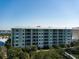 Exterior view of a multi-story condo building with balconies under a blue sky at 5 Riverwalk Dr # 506, New Smyrna Beach, FL 32169