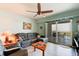 Comfortable living room featuring a plush gray couch, ceiling fan, and sliding glass doors to the balcony at 5 Riverwalk Dr # 506, New Smyrna Beach, FL 32169