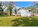 Backyard view of a charming single-story home with a well-maintained lawn and natural surroundings at 526 Powers Ave, Port Orange, FL 32127