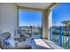 Balcony with two chairs and table with blue cushions and blue railings at 5300 S Atlantic Ave # 3-301, New Smyrna Beach, FL 32169