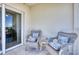 Outdoor balcony features two wicker chairs with patterned cushions and peaceful view at 5300 S Atlantic Ave # 3-301, New Smyrna Beach, FL 32169