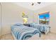 Cozy bedroom featuring two twin beds with a window view of palm trees and blue skies at 5300 S Atlantic Ave # 3-301, New Smyrna Beach, FL 32169