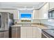 Modern kitchen with white cabinets, stainless steel appliances, and a window providing natural light at 5300 S Atlantic Ave # 3-301, New Smyrna Beach, FL 32169