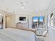 Light-filled main bedroom with a balcony, television, and serene atmosphere at 5300 S Atlantic Ave # 3-301, New Smyrna Beach, FL 32169