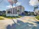Beautiful Oceanwalk Condominiums building exterior view with a manicured lawn, sign and palm trees at 5300 S Atlantic Ave # 7-307, New Smyrna Beach, FL 32169