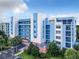 Beautiful building with multiple balconies, well landscaped with palm trees, blue and white design at 5300 S Atlantic Ave # 7-307, New Smyrna Beach, FL 32169