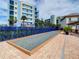 Community bocce ball court with beautiful pavers, blue fence, lush foliage, and a view of the condos at 5300 S Atlantic Ave # 7-307, New Smyrna Beach, FL 32169