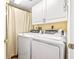 Convenient laundry room features a stacked washer and dryer and built in white cabinets for storage at 5300 S Atlantic Ave # 7-307, New Smyrna Beach, FL 32169