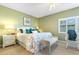 Cozy main bedroom features an accent wall, a ceiling fan, and plantation shutters for optimal light control at 5300 S Atlantic Ave # 7-307, New Smyrna Beach, FL 32169