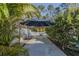 Backyard concrete path with tropical greenery, offering privacy and relaxation at 5424 Frederick Lake Dr, Port Orange, FL 32128