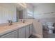Bathroom with double vanity, gray accent wall, and tile flooring at 5424 Frederick Lake Dr, Port Orange, FL 32128