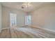 Bedroom with wood-look flooring, ceiling fan, and view to bathroom and kitchen at 5424 Frederick Lake Dr, Port Orange, FL 32128