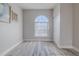 Bright bedroom with a large arched window, light gray walls and wood-look flooring at 5424 Frederick Lake Dr, Port Orange, FL 32128