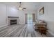 Cozy living room with a fireplace, wood floors, and neutral-toned furniture at 5424 Frederick Lake Dr, Port Orange, FL 32128