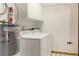 Bright laundry room with washer, dryer, storage cabinets, and Rheem water heater for efficiency at 55 Bay Harbour Dr, Ponce Inlet, FL 32127