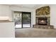 Cozy living room with a stone fireplace and sliding doors to the backyard at 55 Bay Harbour Dr, Ponce Inlet, FL 32127