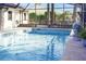 A screened in pool with clear blue water, and a small mermaid statue by the pool deck at 55 Bay Harbour Dr, Ponce Inlet, FL 32127