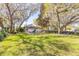Spacious backyard with mature trees offering plenty of shade, complemented by an outdoor seating area at 6049 Sabal Hammock Cir, Port Orange, FL 32128