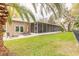 Exterior view of the house showing the screened-in patio and backyard seating area at 6049 Sabal Hammock Cir, Port Orange, FL 32128