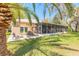 Backyard patio with outdoor seating and a screened-in lanai, perfect for enjoying the beautiful surroundings at 6049 Sabal Hammock Cir, Port Orange, FL 32128