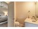 Bright bathroom with toilet, vanity, and an open door that leads to the bedroom at 6049 Sabal Hammock Cir, Port Orange, FL 32128