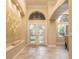 Elegant foyer boasts high ceilings, arched windows, tile flooring, and double doors at 6049 Sabal Hammock Cir, Port Orange, FL 32128
